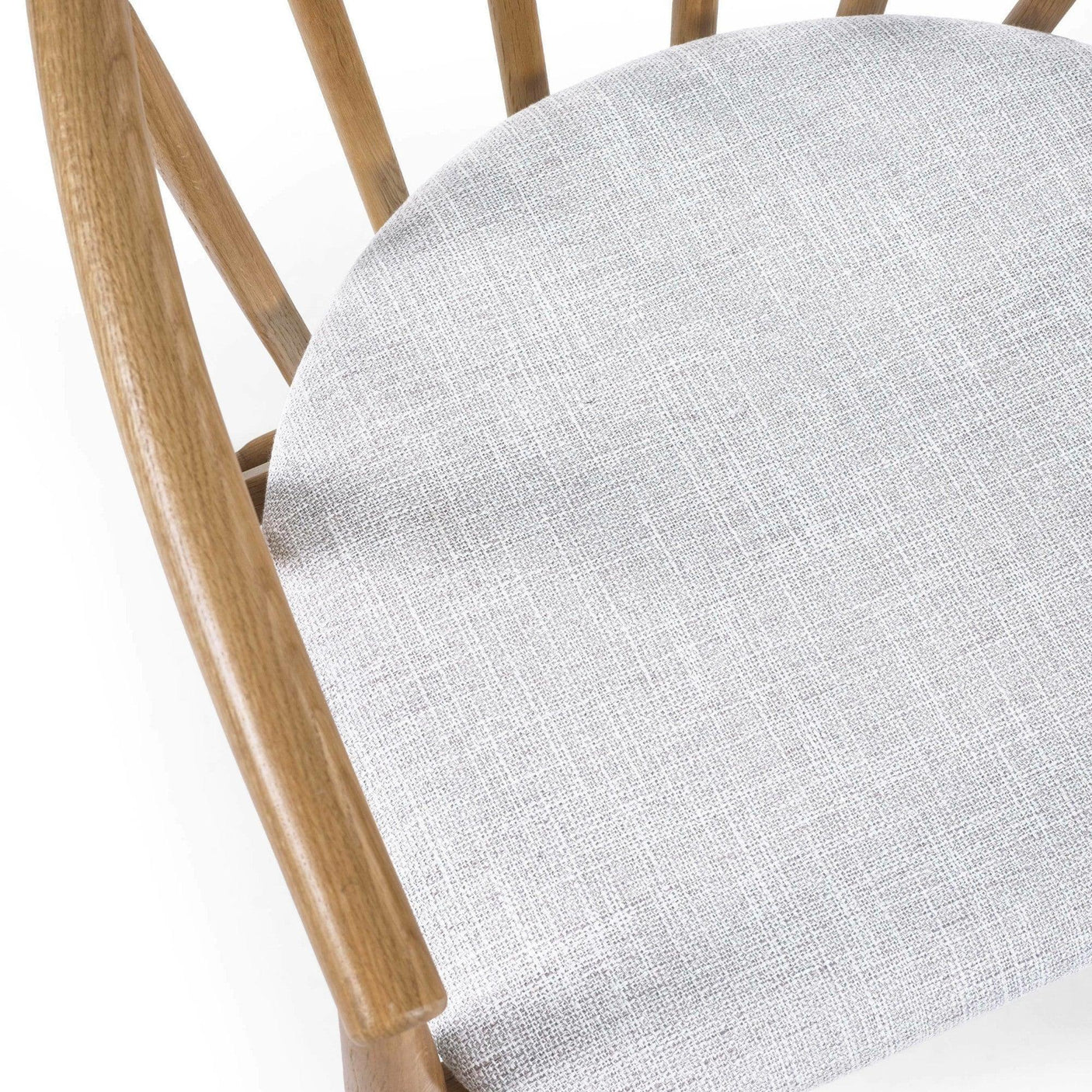 Closeup of light grey fabric dining chair seat with natural wood frame