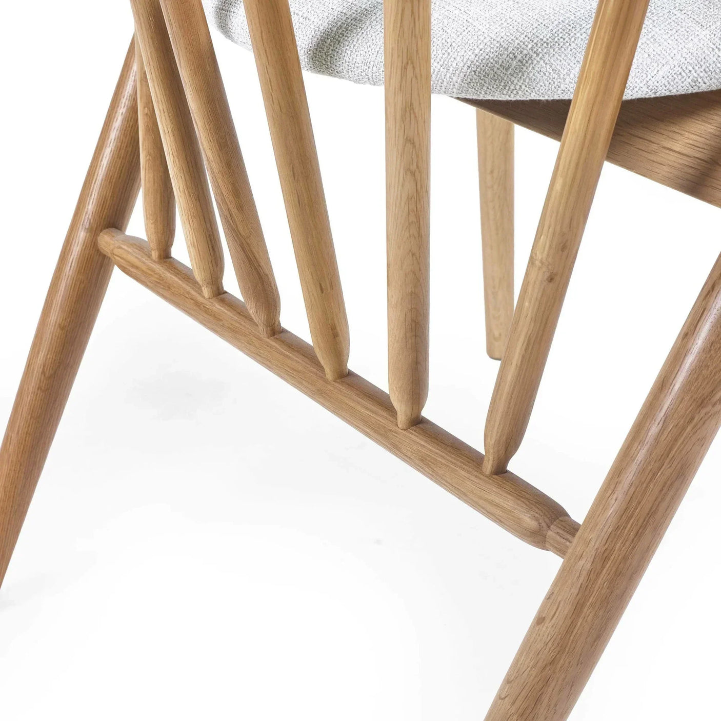 Close-up of oak dining chair spindle back and fabric seat detail