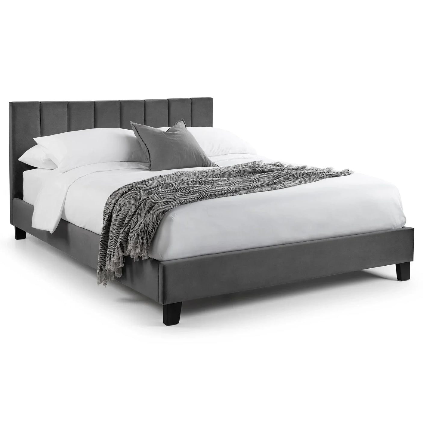 Grey velvet single bed with panelled headboard, dressed in white bedding and throw