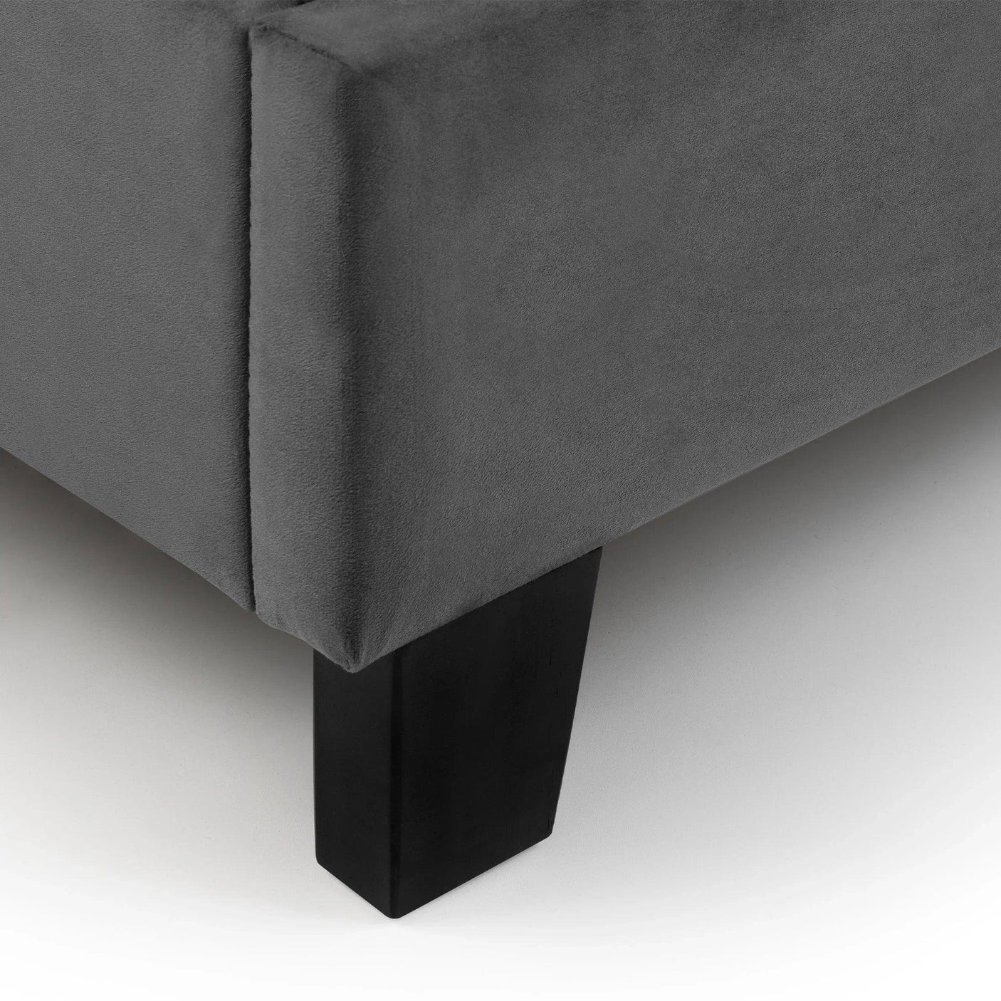 Grey velvet single bed frame corner with black wood leg detail