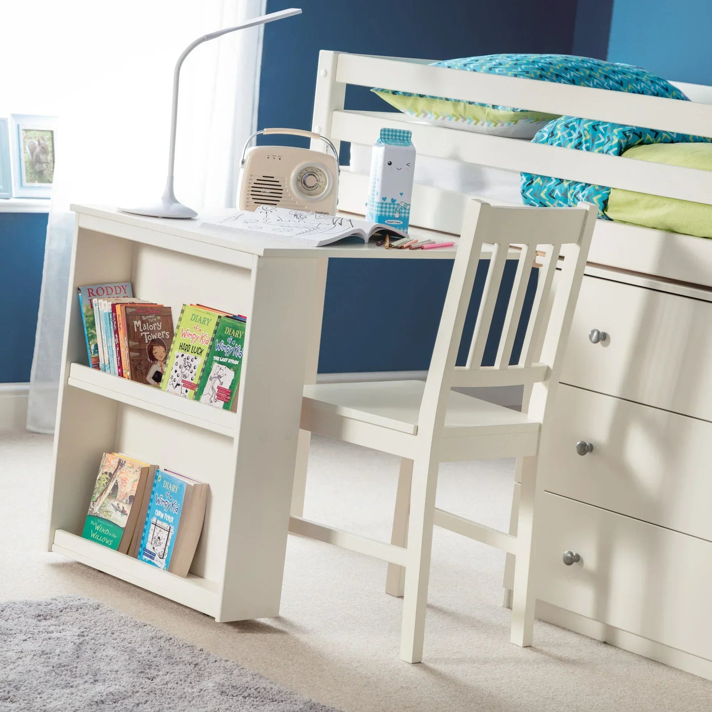 White sleepstation desk with chair, bookshelf, and storage drawers in a child's bedroom