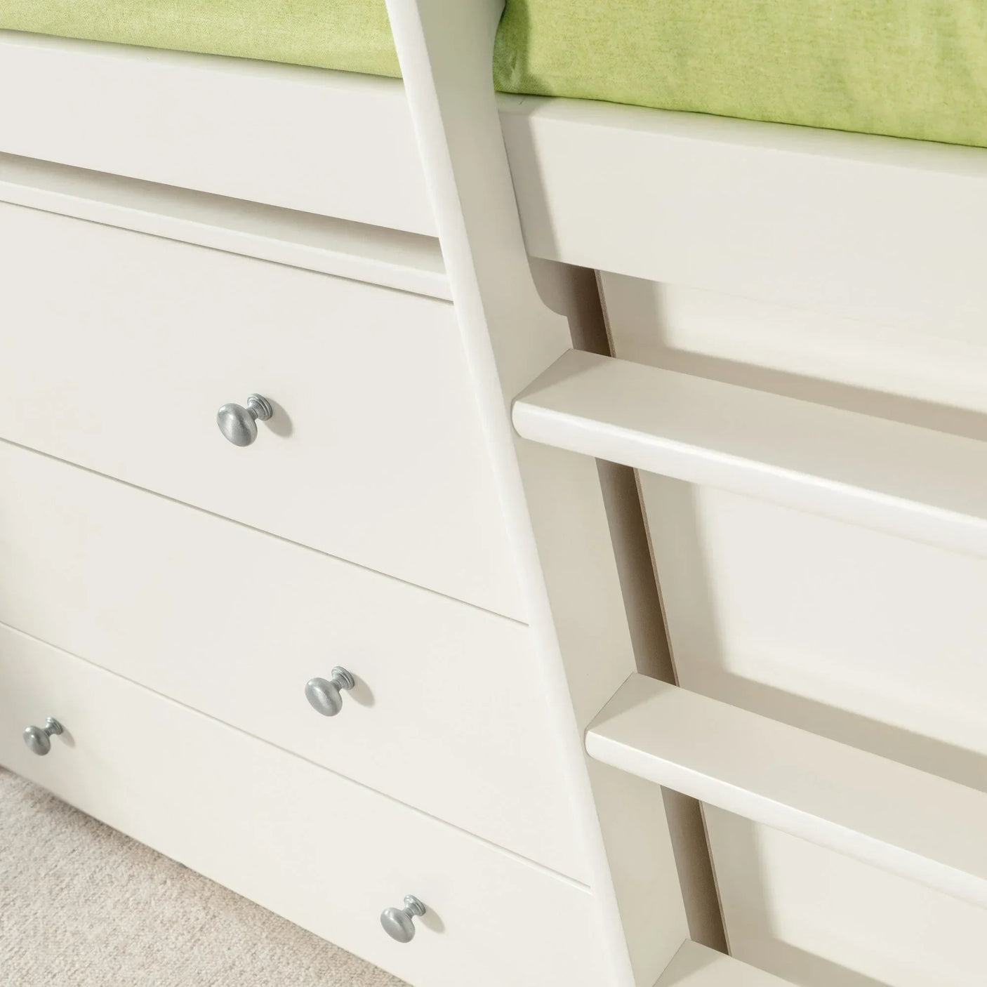 White sleepstation bed with built-in drawers, ladder, and green mattress corner detail