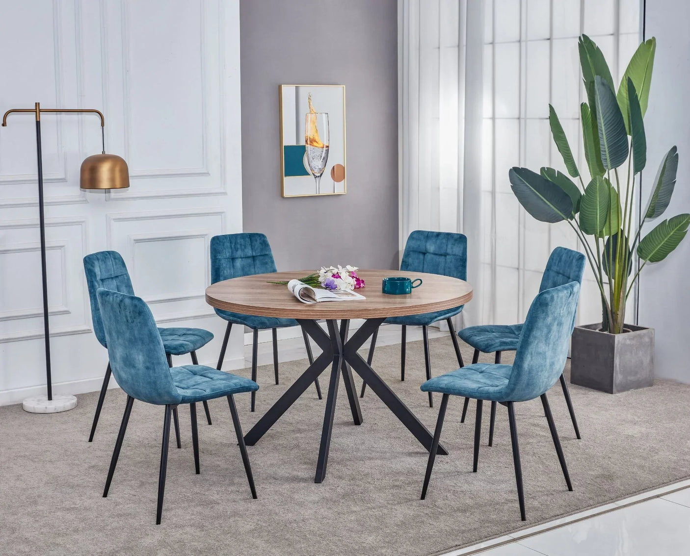 Round walnut dining table with six blue velvet chairs in modern dining room setting