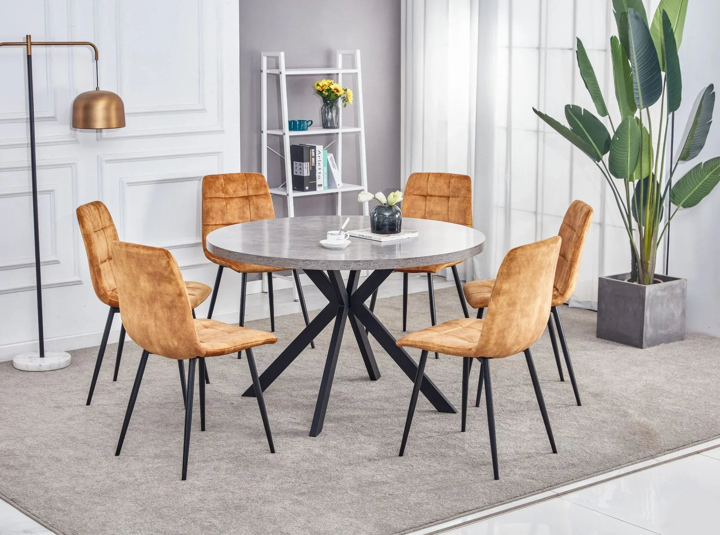 Round marble dining table with black metal legs and six tan velvet chairs in modern room