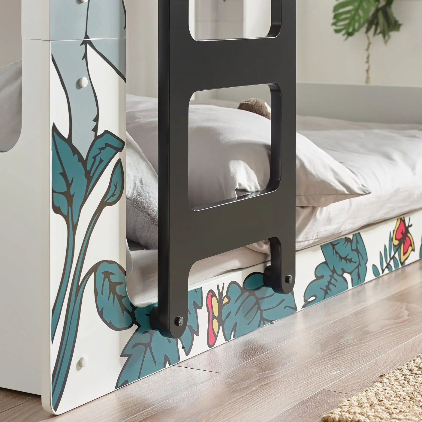 Children’s bunk bed with safari print panel, black ladder, and light wooden floor