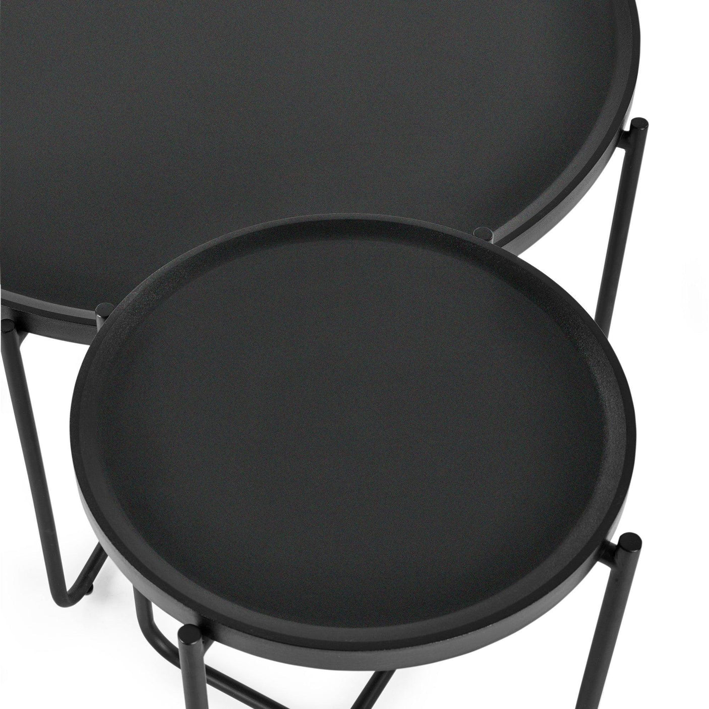 Black metal nesting tables with round trays and slim legs, close overhead view