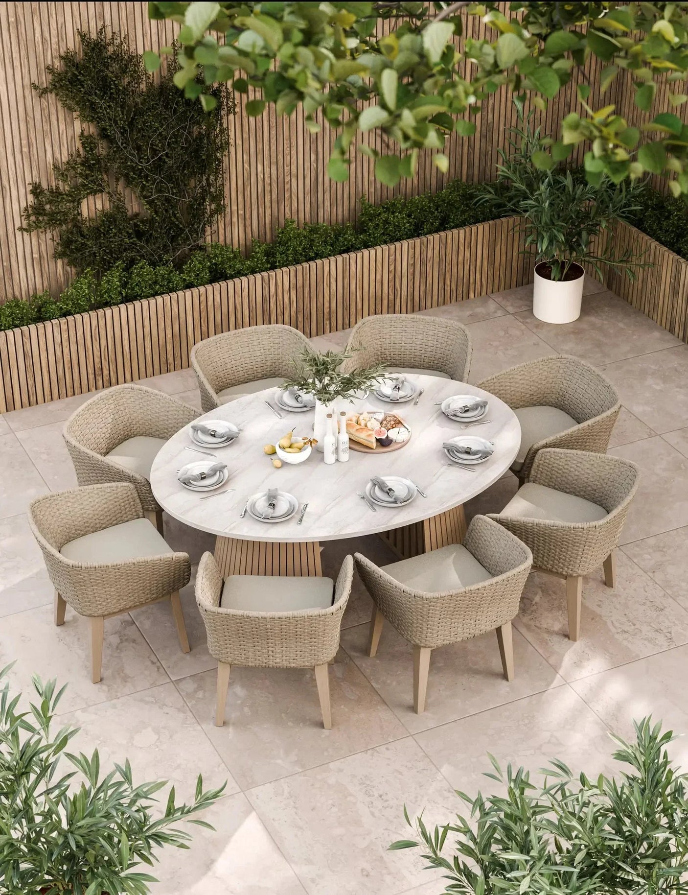 Round outdoor dining set with eight rattan chairs and marble table on tiled patio