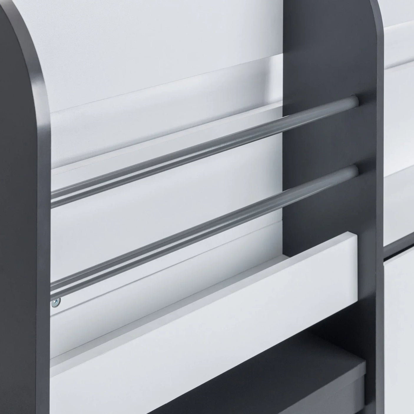 Grey and white bed frame with safety rails and built-in storage shelves, side view