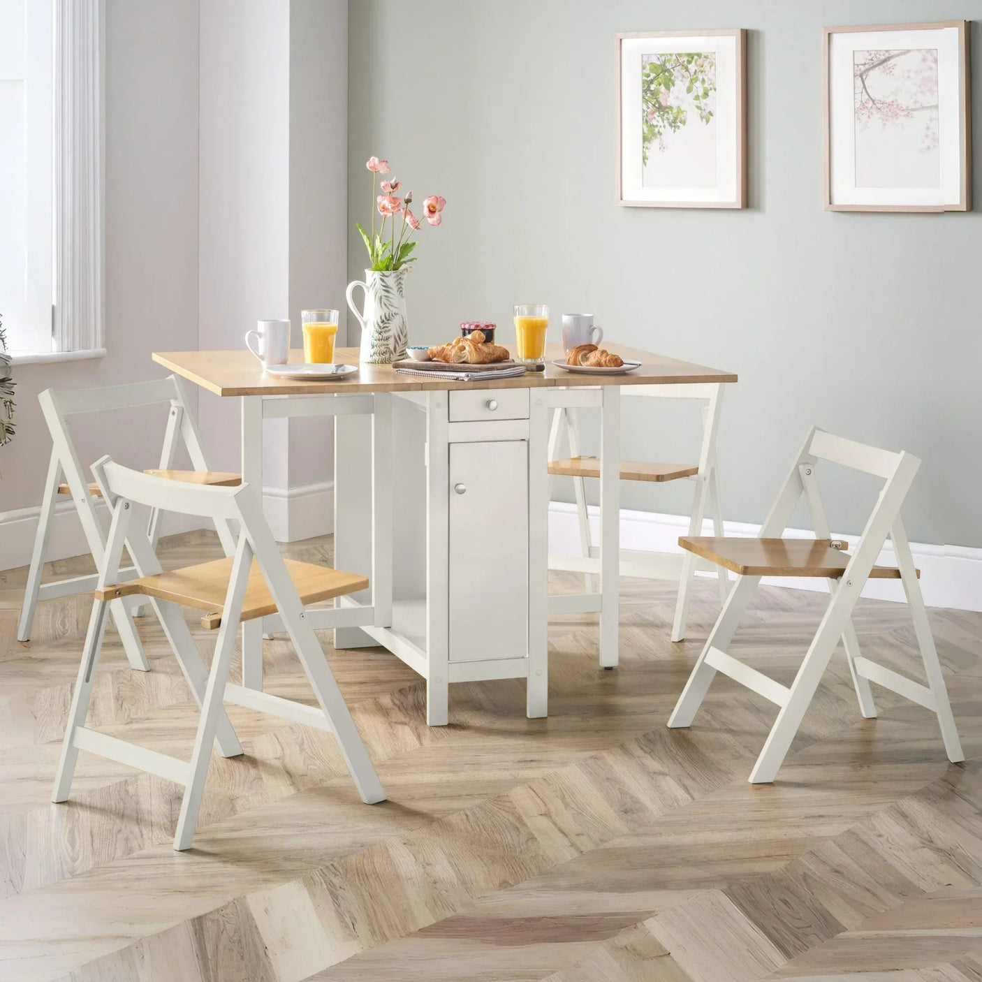 Space-saving dining table set with four folding chairs in light wood and white finish