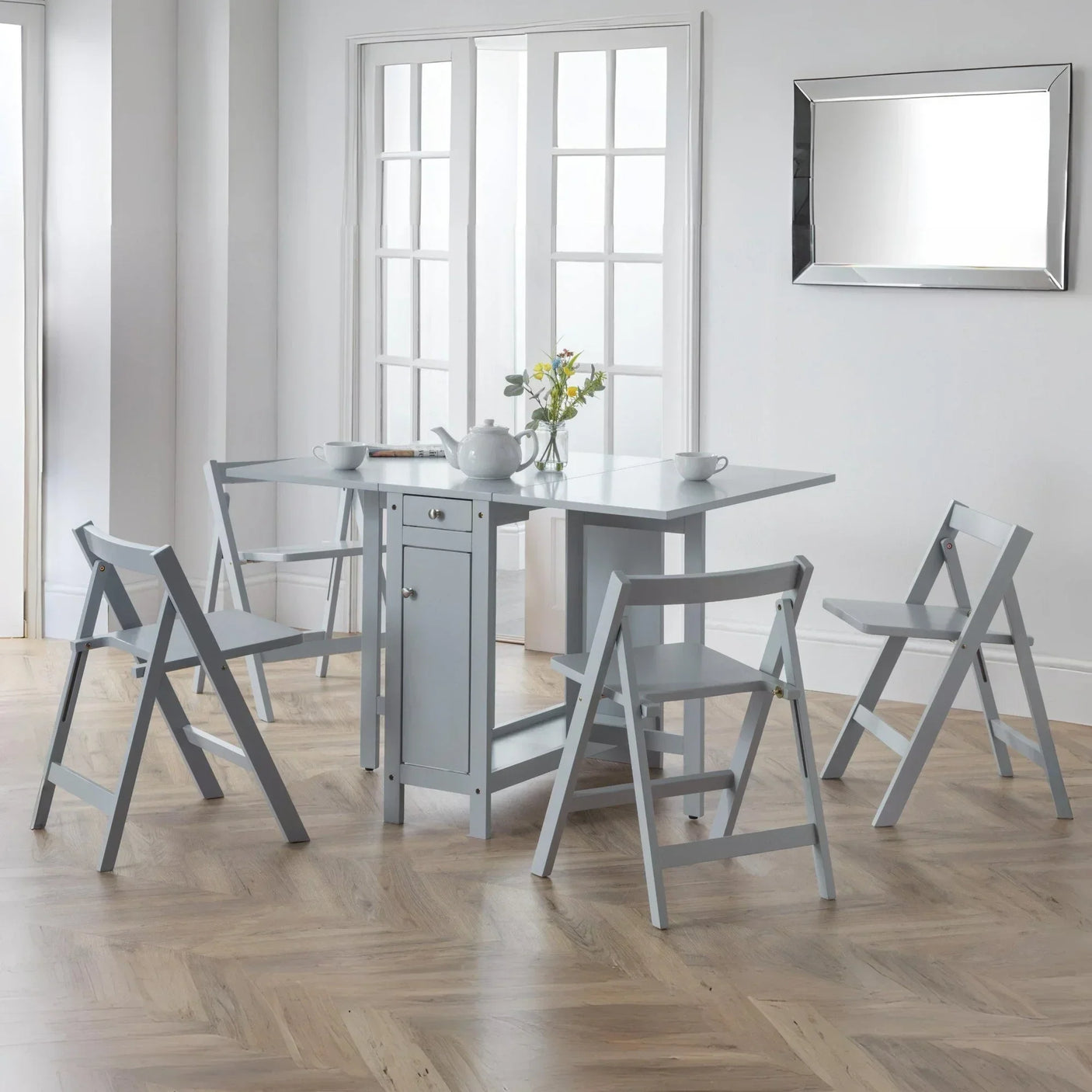 Grey folding dining table set with four chairs in modern kitchen setting