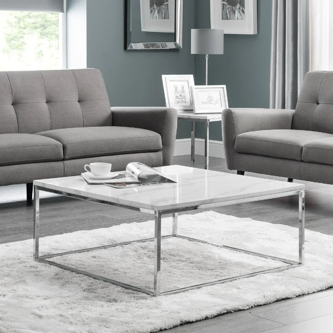 Square marble coffee table with chrome frame on white rug in modern living room