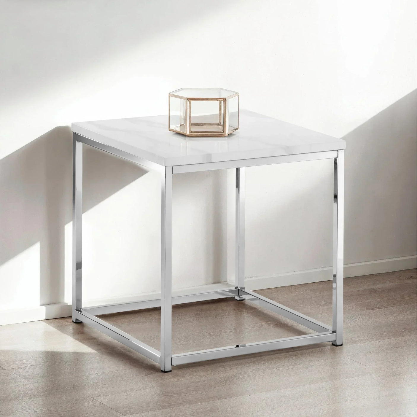 White marble effect side table with chrome frame and glass decor on wooden floor