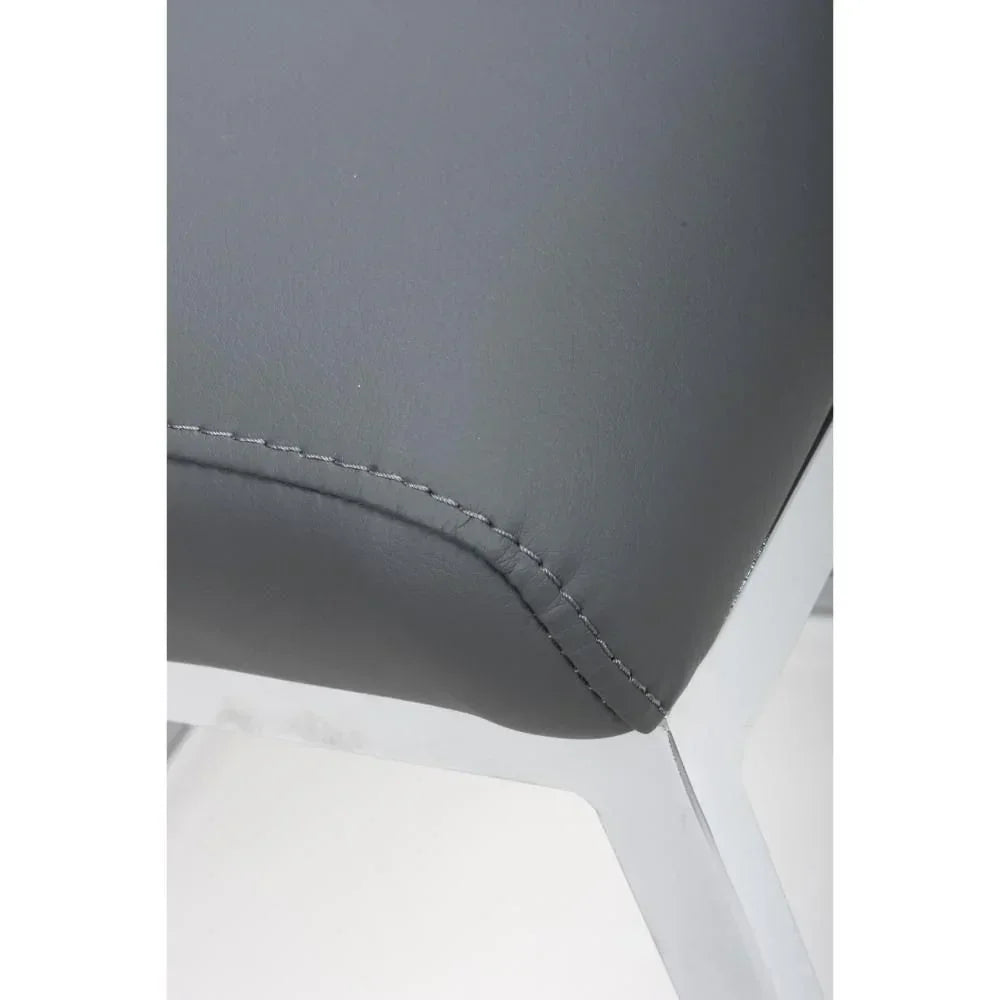 Close-up of grey faux leather dining chair seat with visible stitching on metal frame
