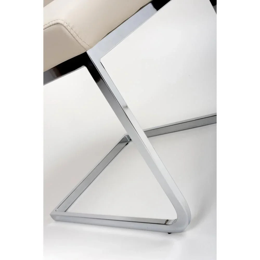 Chrome cantilever dining chair base with cream padded seat closeup