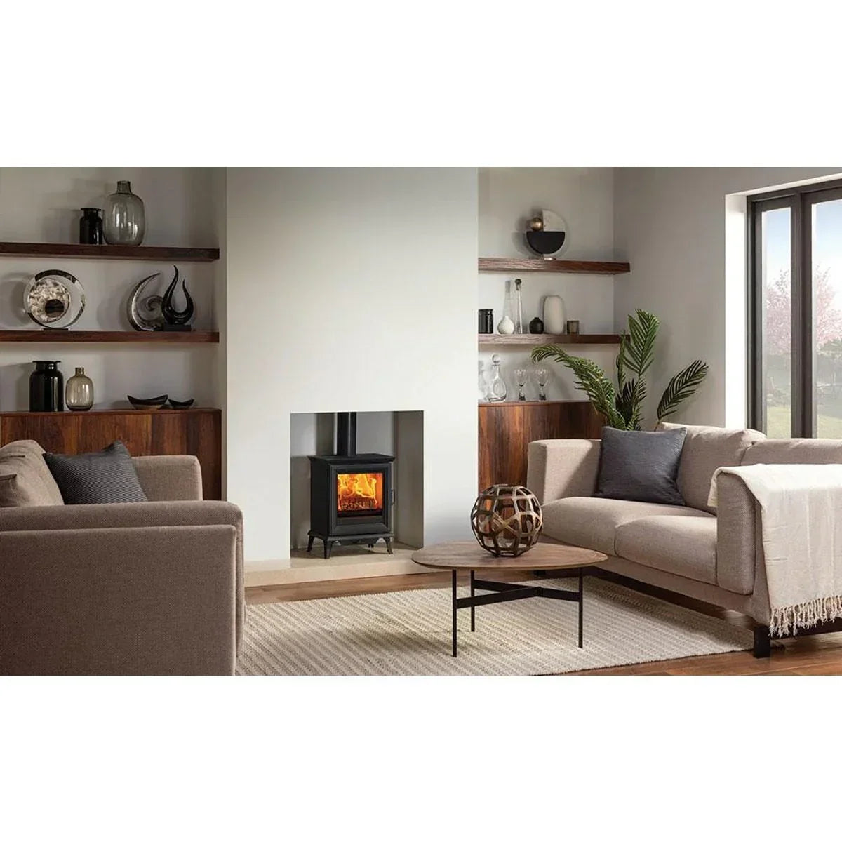 Modern living room with beige sofas, wood burning stove, and wooden coffee table
