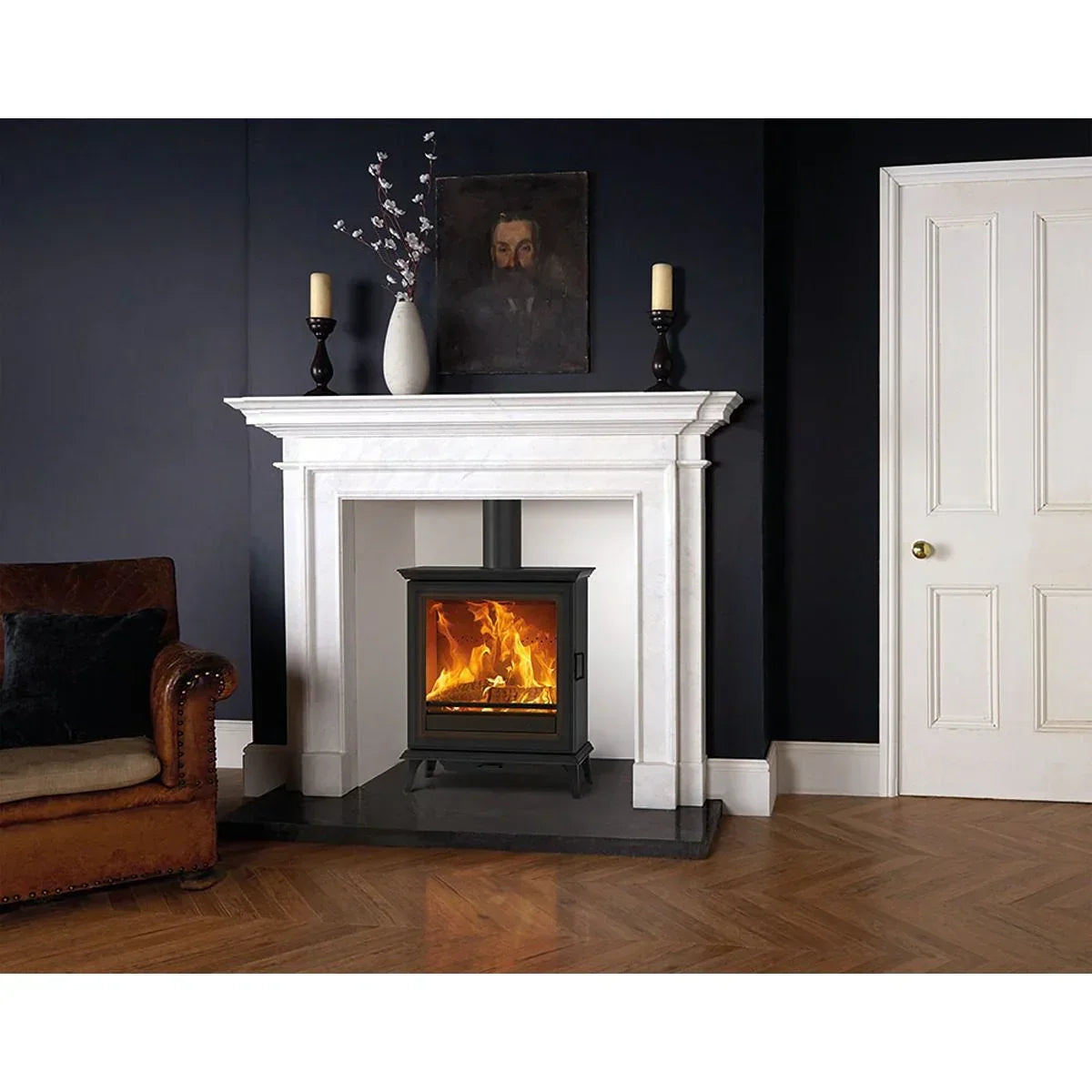 Black wood burning stove with glass door inside white marble fireplace in modern living room