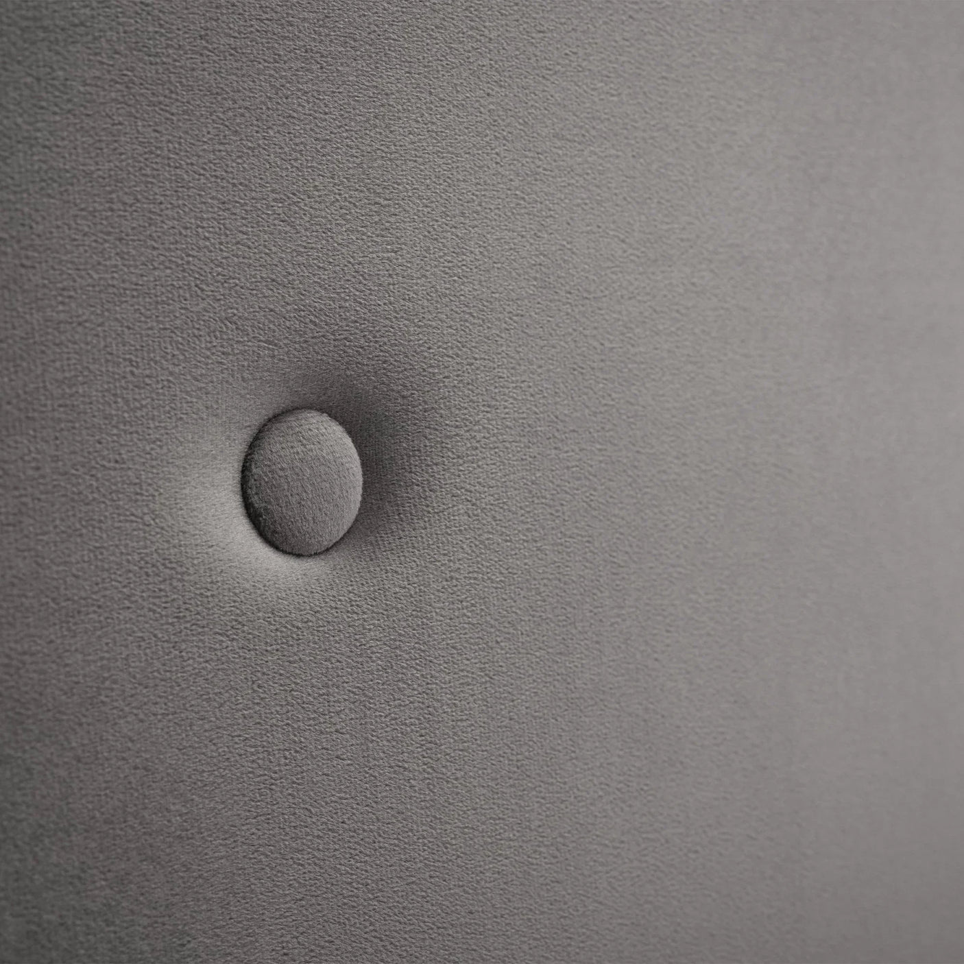 Close-up of grey upholstery on storage bed headboard with button detail