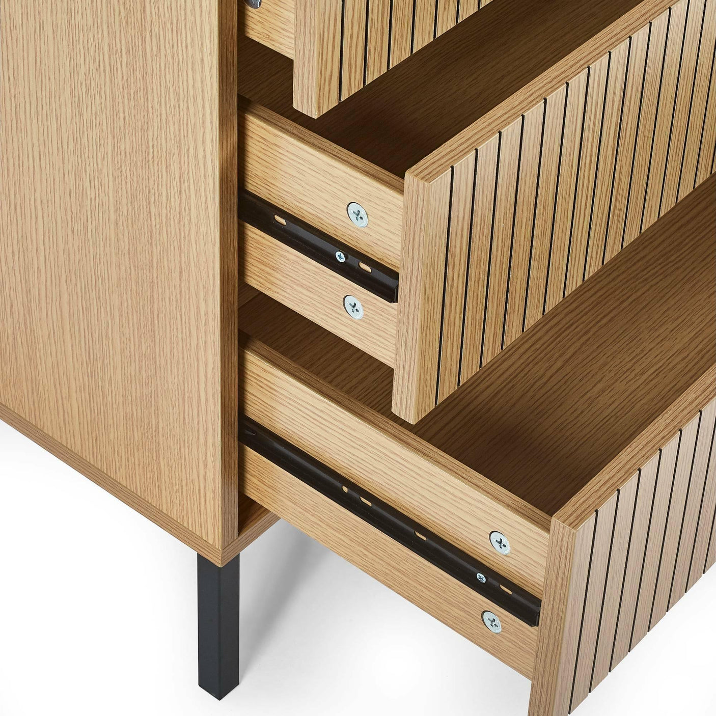 Close-up of oak chest of drawers with vertical slatted fronts and black metal legs