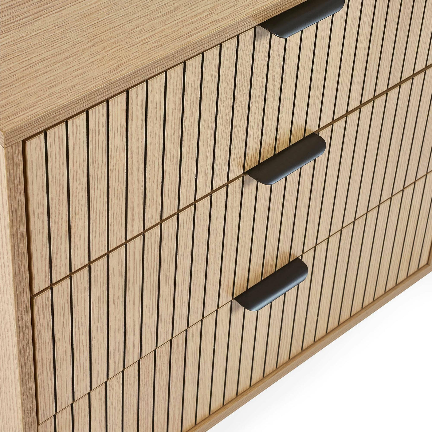 Oak chest of drawers with black handles and vertical slatted design, close-up view