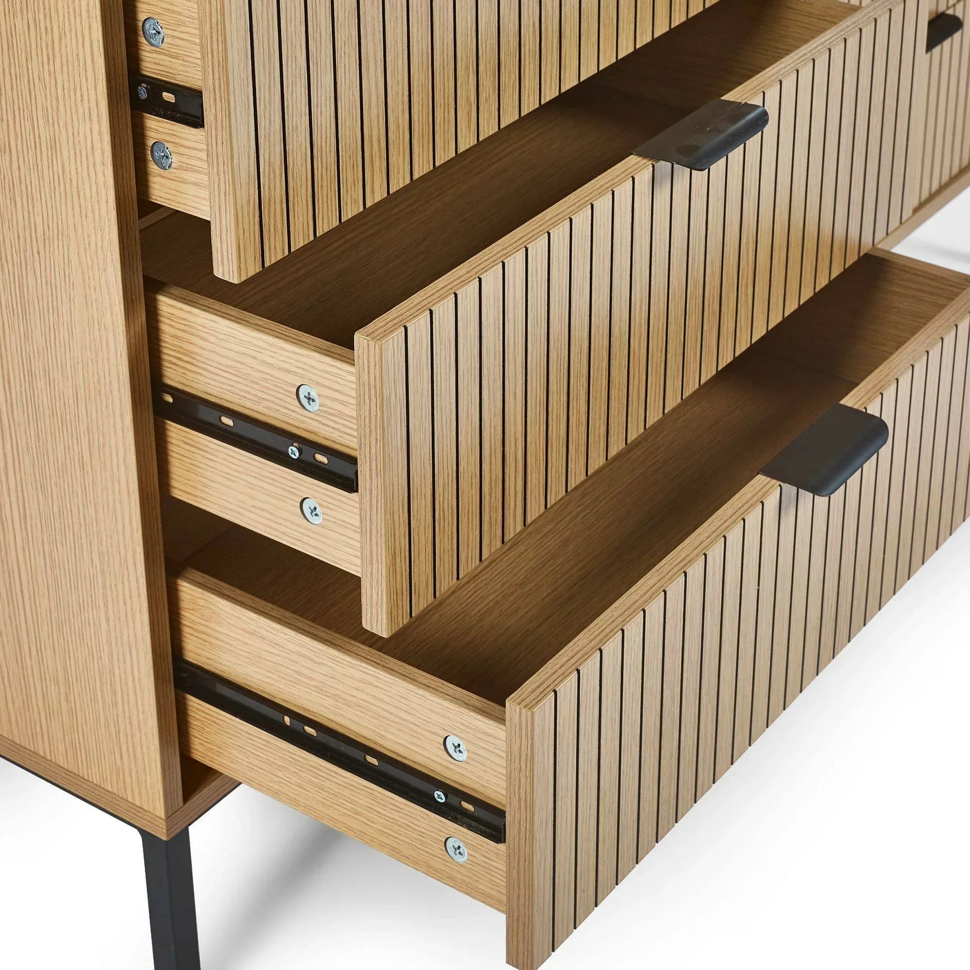 Closeup of oak chest of drawers with black handles and slatted wood front open