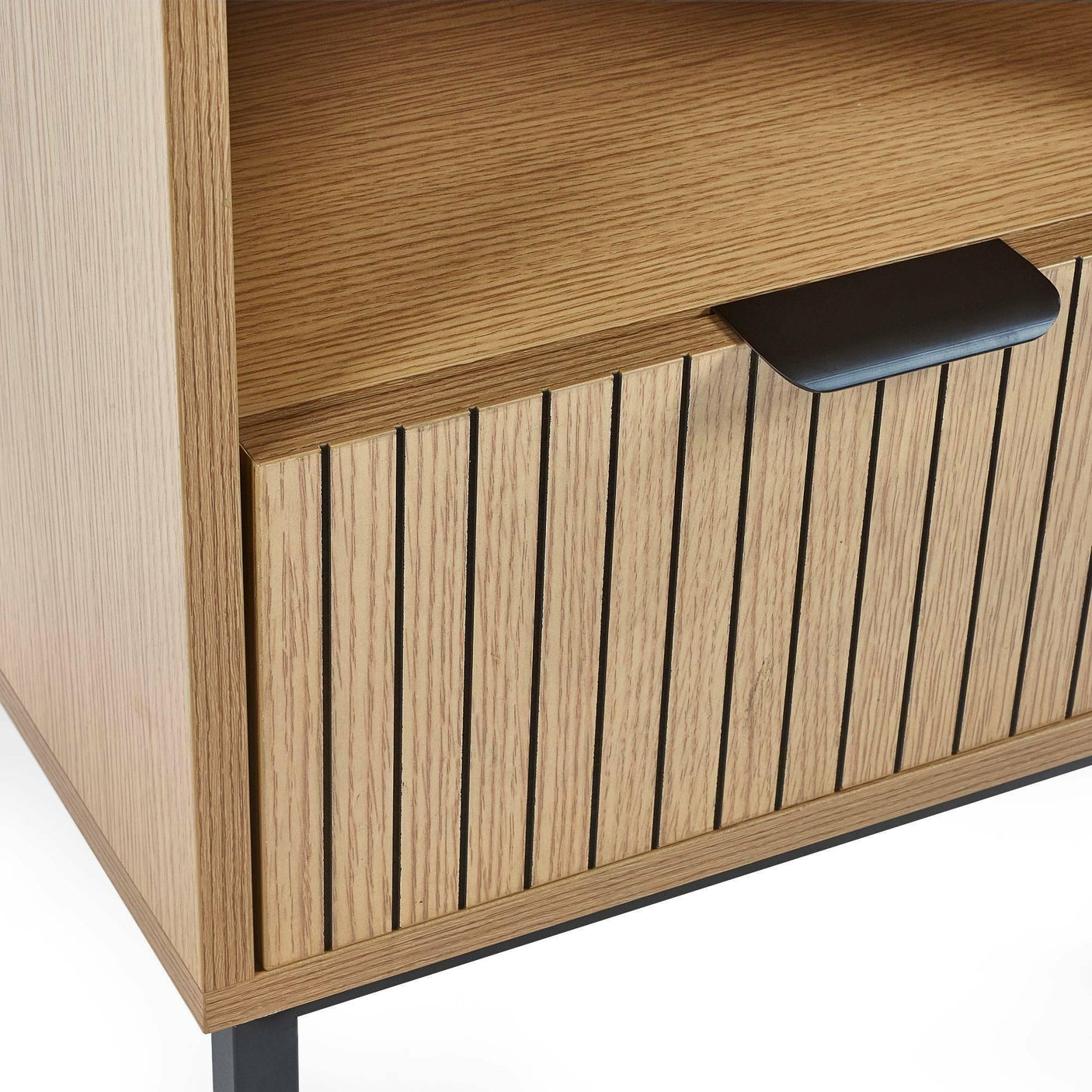 Close-up of wood slatted cabinet drawer with black handle and open shelf above