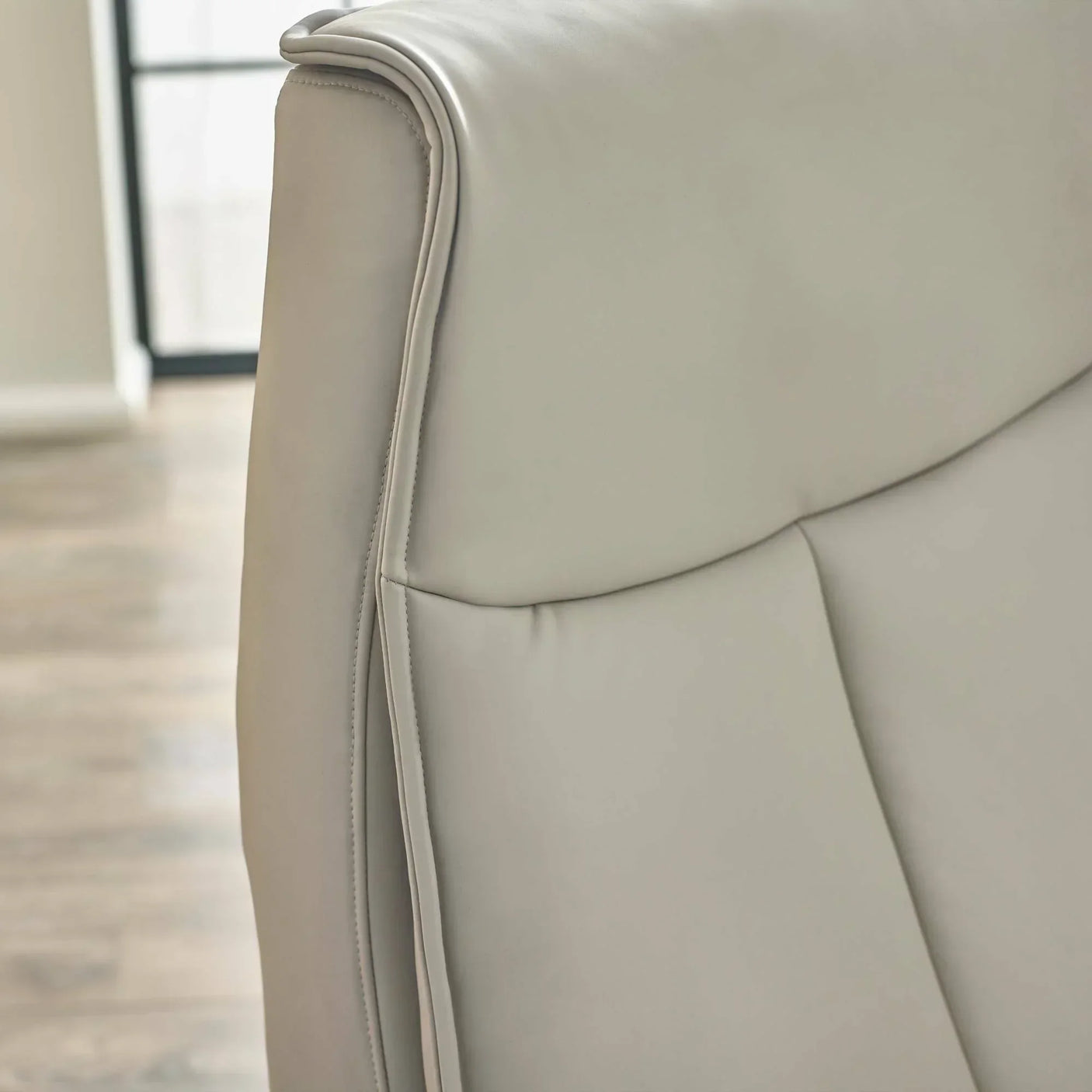 Closeup of light grey Sofia dual recliner backrest with smooth faux leather upholstery
