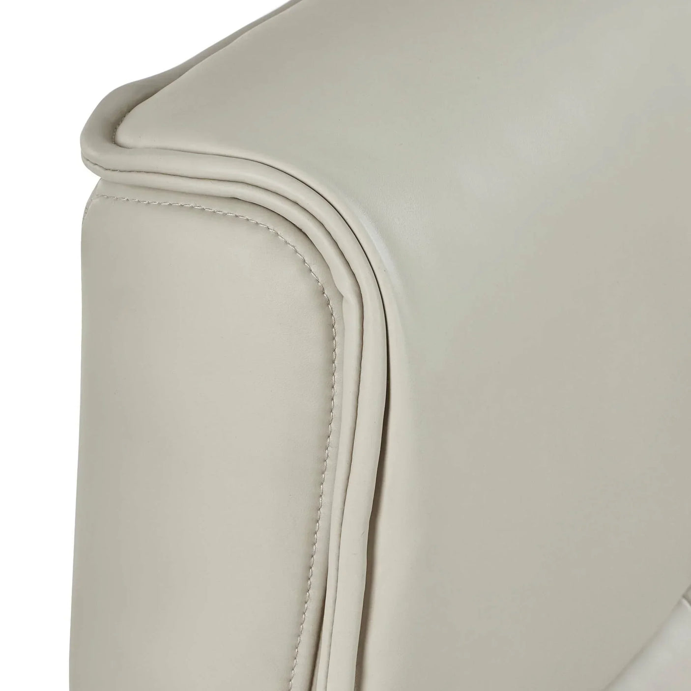 Closeup of cream leather sofa armrest with detailed stitching