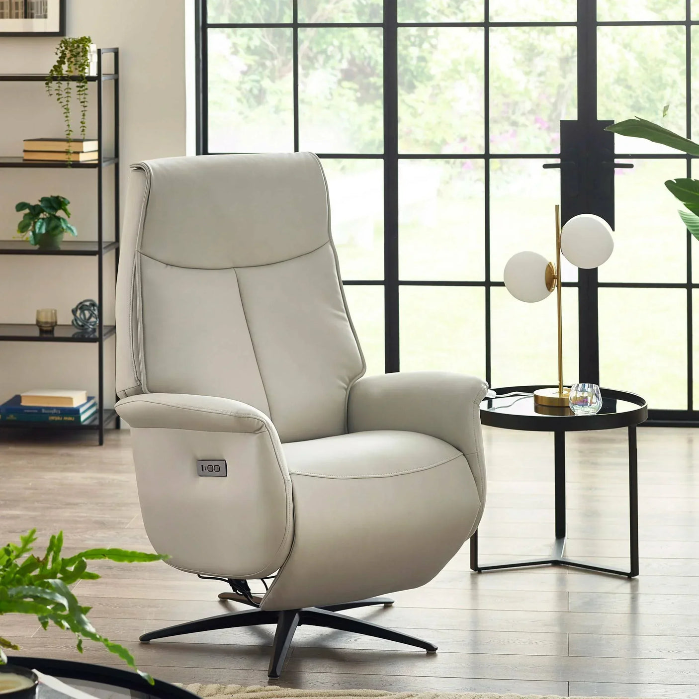 Light grey leather recliner chair with swivel base beside side table in modern living room