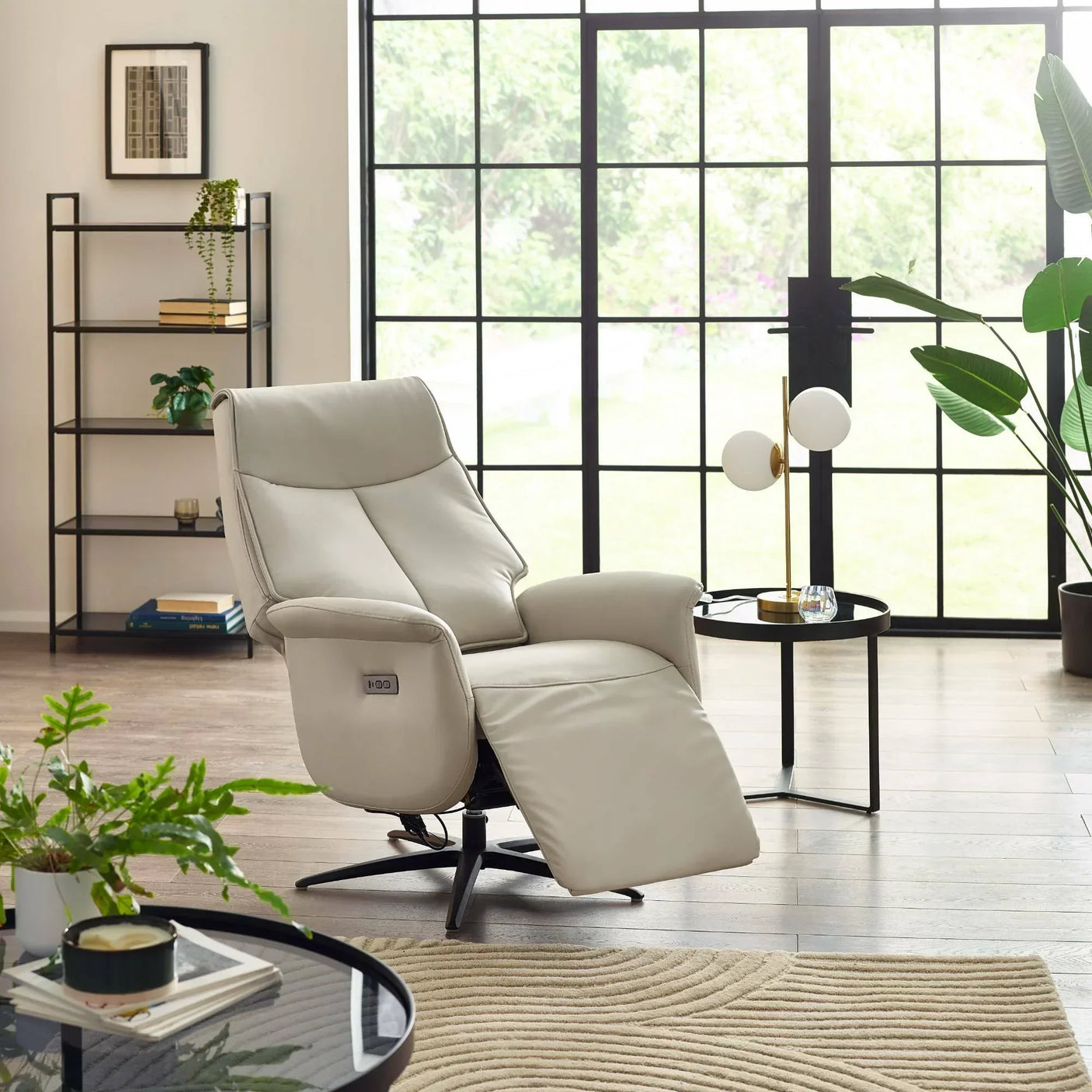 Cream dual recliner chair in bright living room with large windows and indoor plants