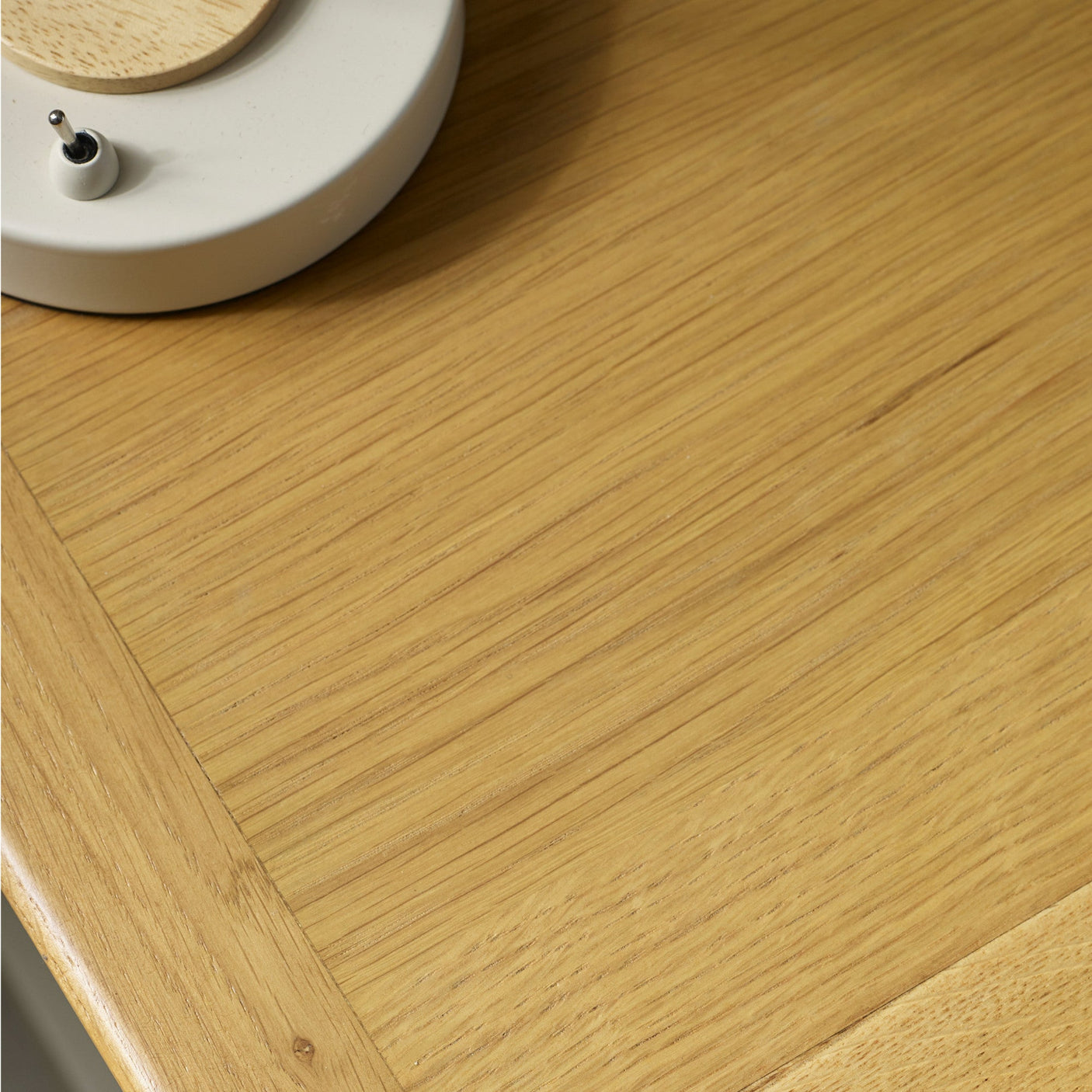 Close-up of natural wood grain on bedside table top, emphasizing fine vertical and diagonal wood lines