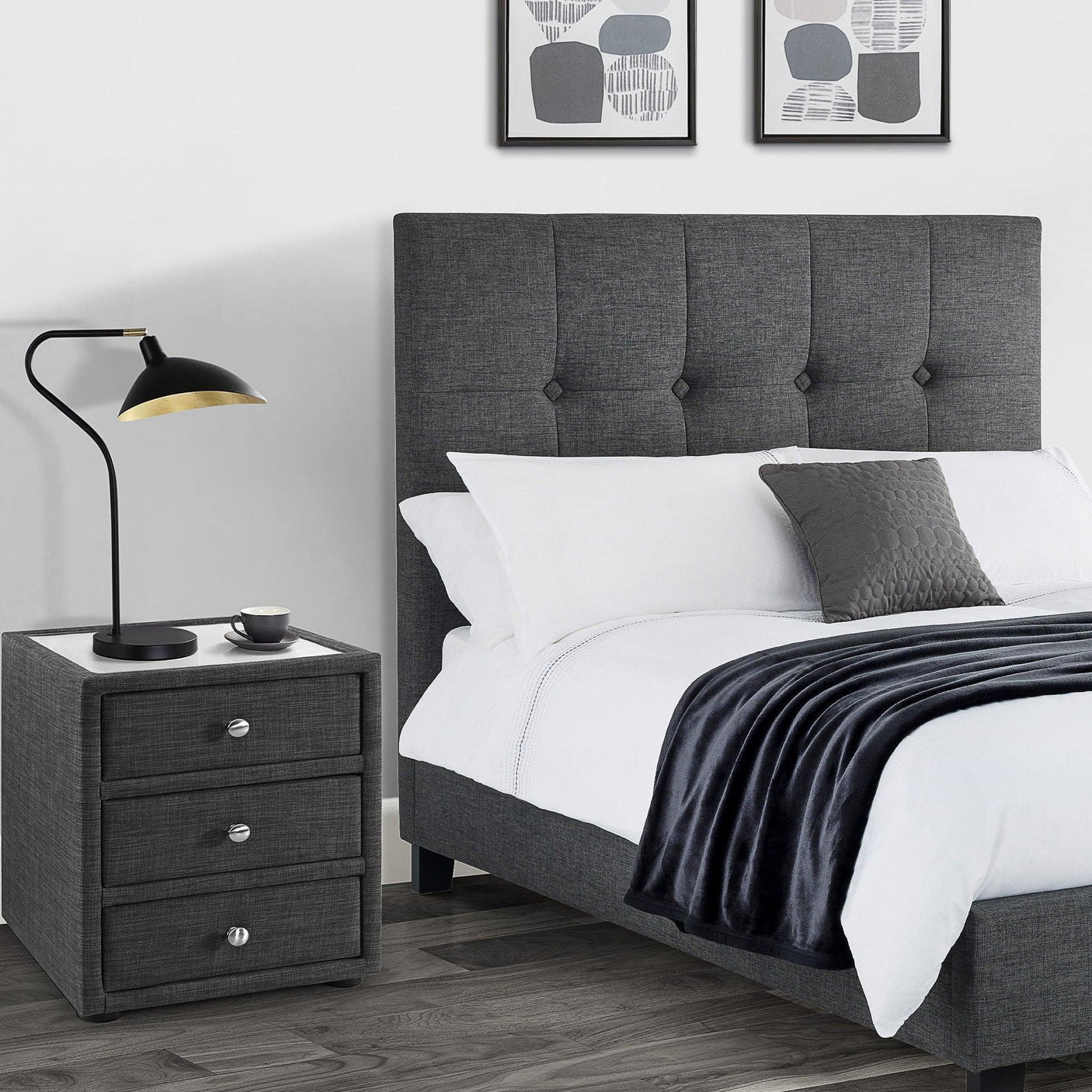 Slate linen three drawer bedside table next to upholstered bed in modern bedroom