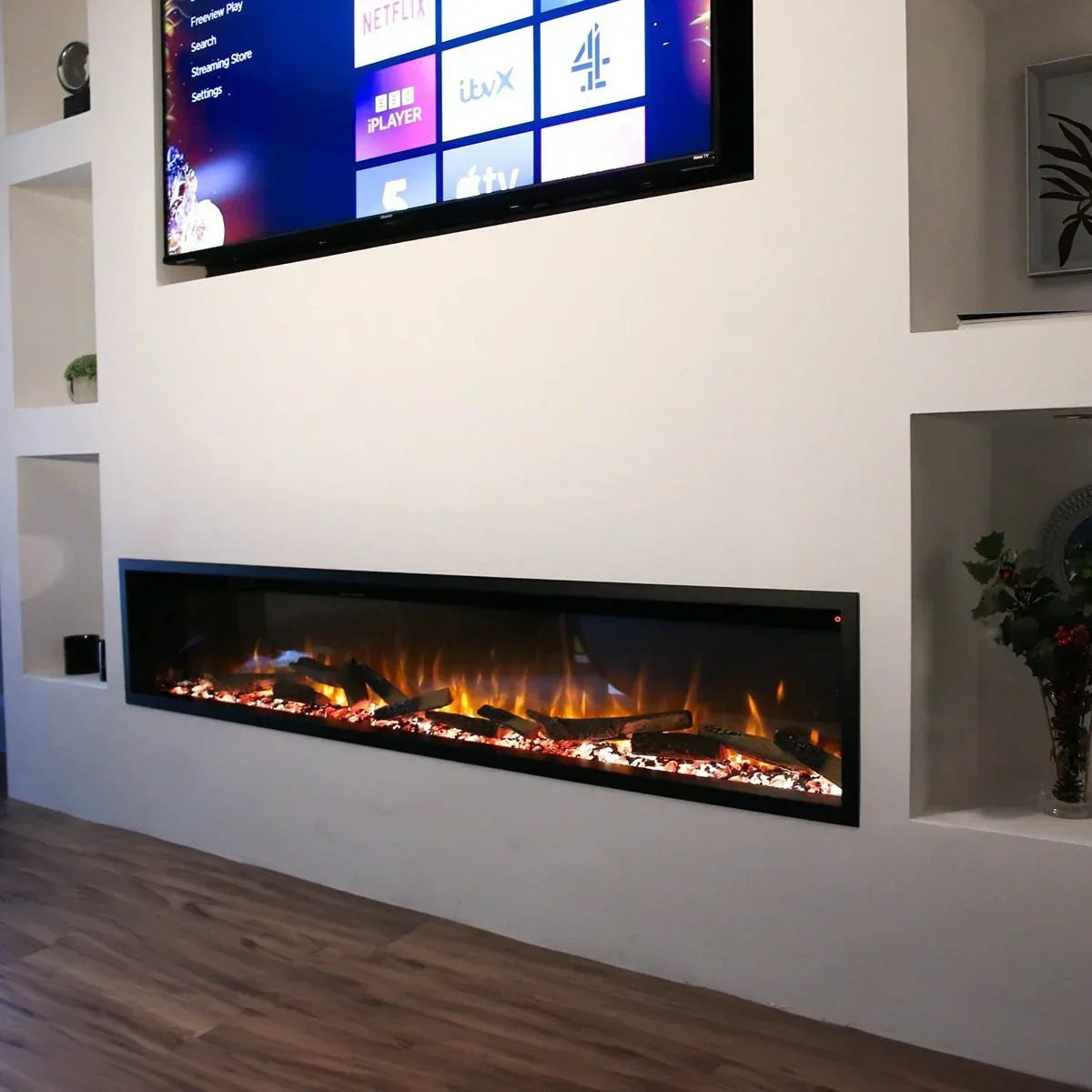 Wall mounted electric fire with LED flame effect below TV in modern living room setting