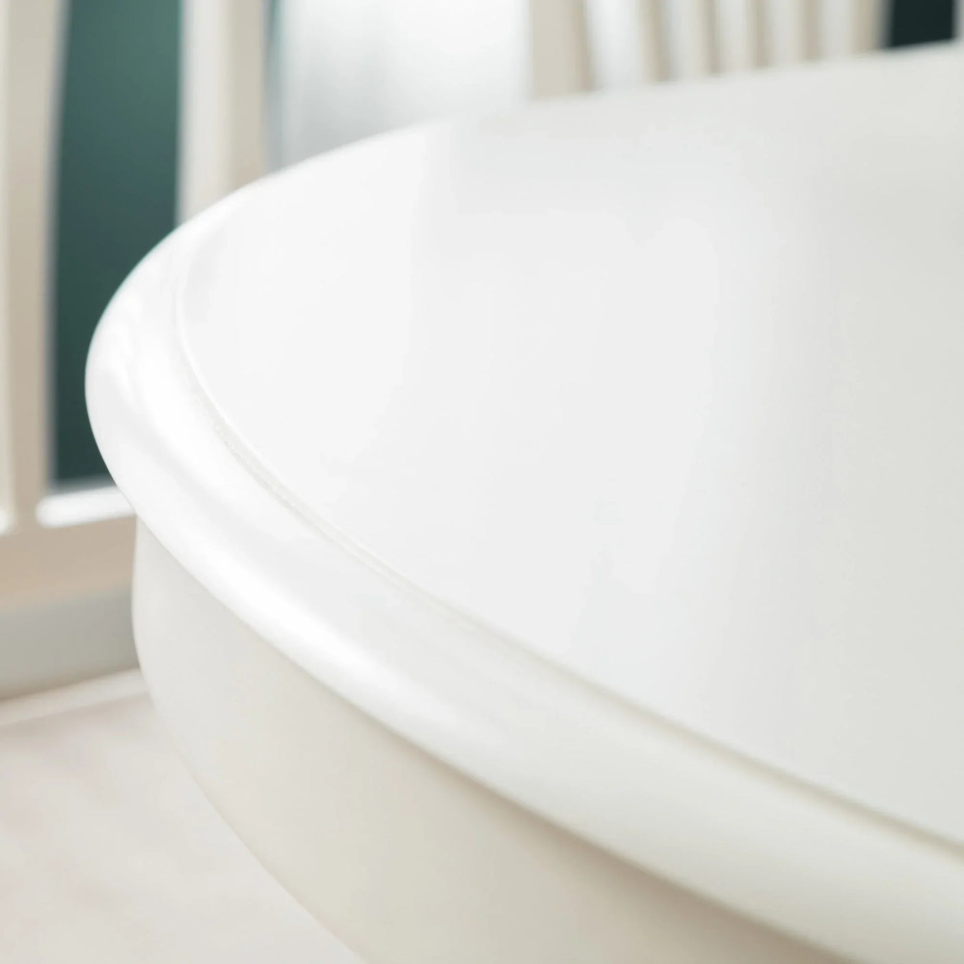 Closeup of round white dining table edge with smooth wood finish