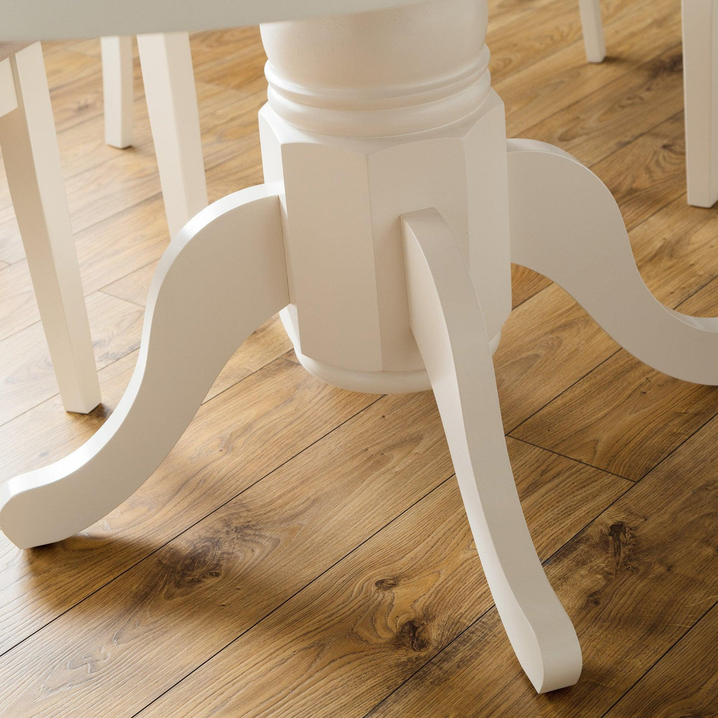 Cream painted dining table pedestal base on wood floor