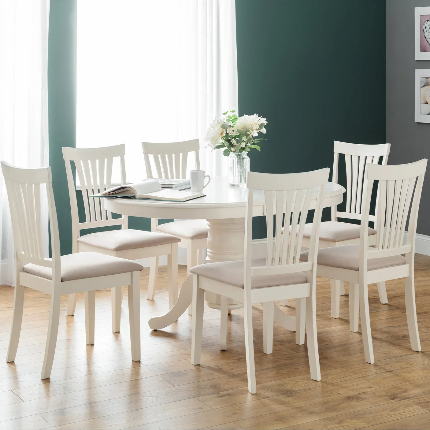 Ivory dining table with matching chairs set on wooden floor in bright room