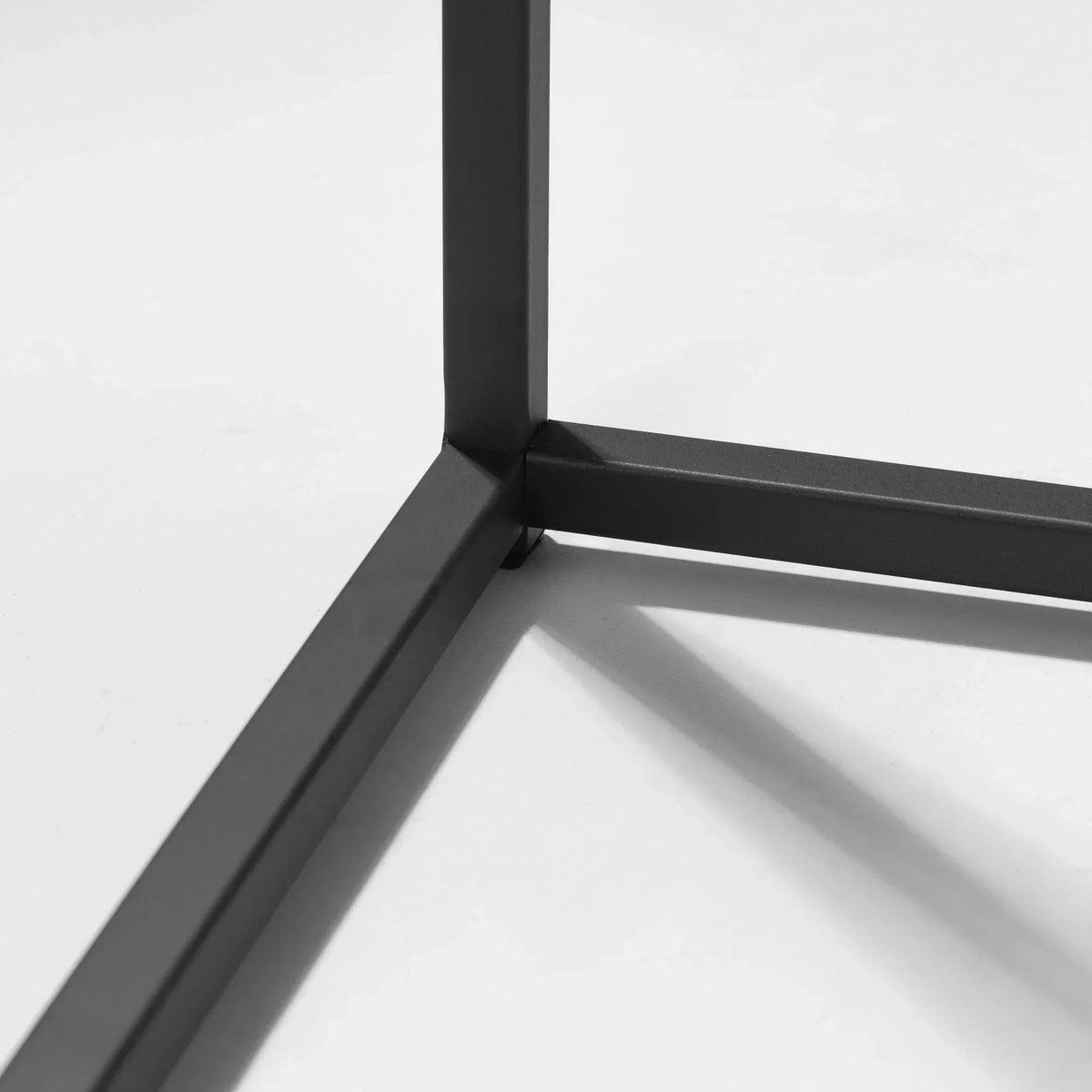 Black metal coffee table leg detail on white background
