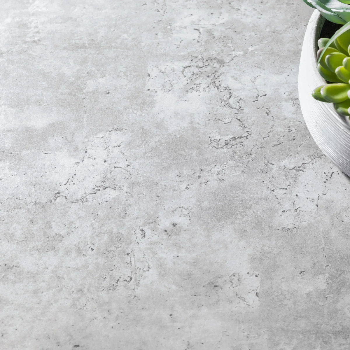 Close detail of grey coffee table surface with textured finish and partial succulent decor