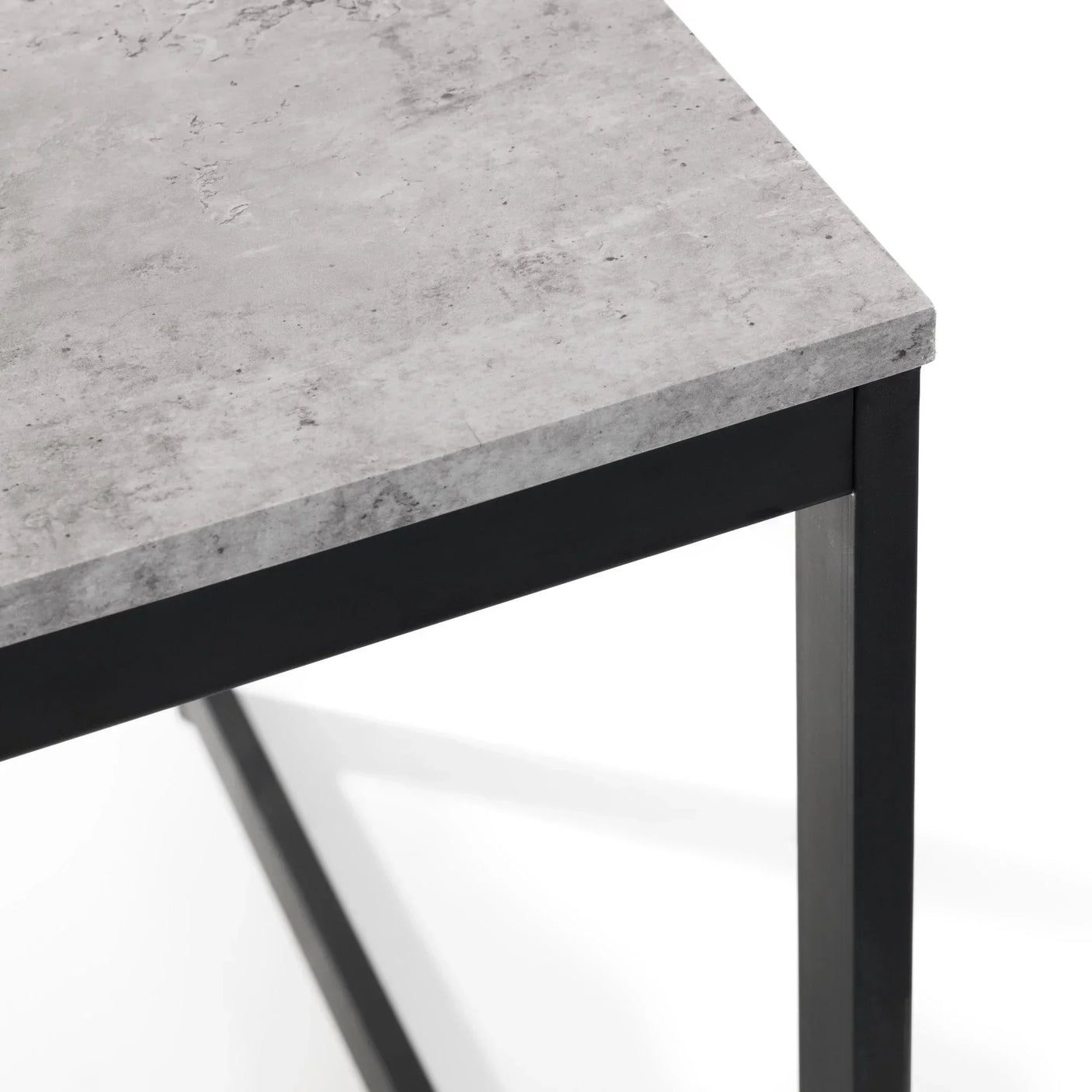 Closeup of concrete effect dining table corner with black metal legs