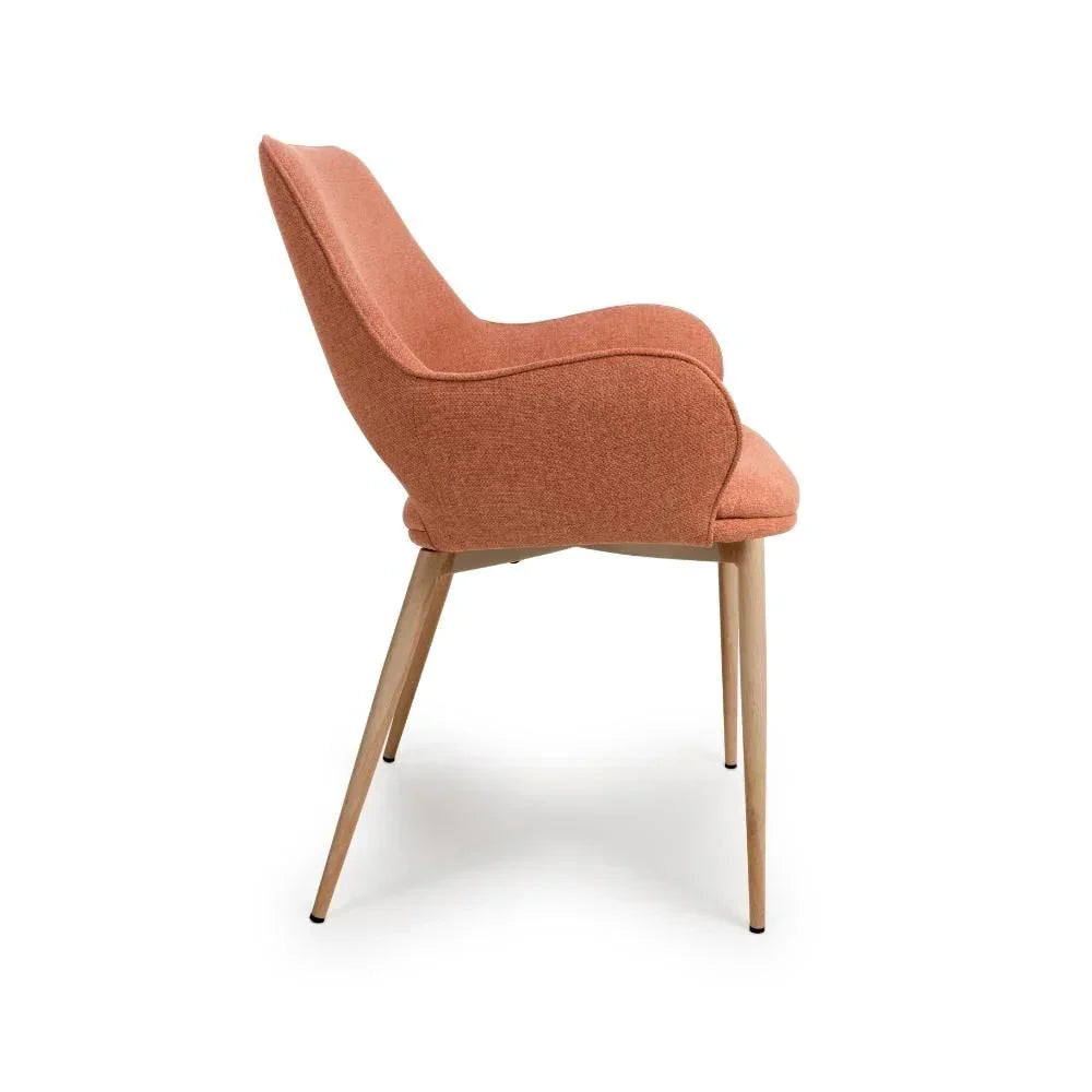 Side view of orange upholstered dining chair with curved backrest and wooden legs