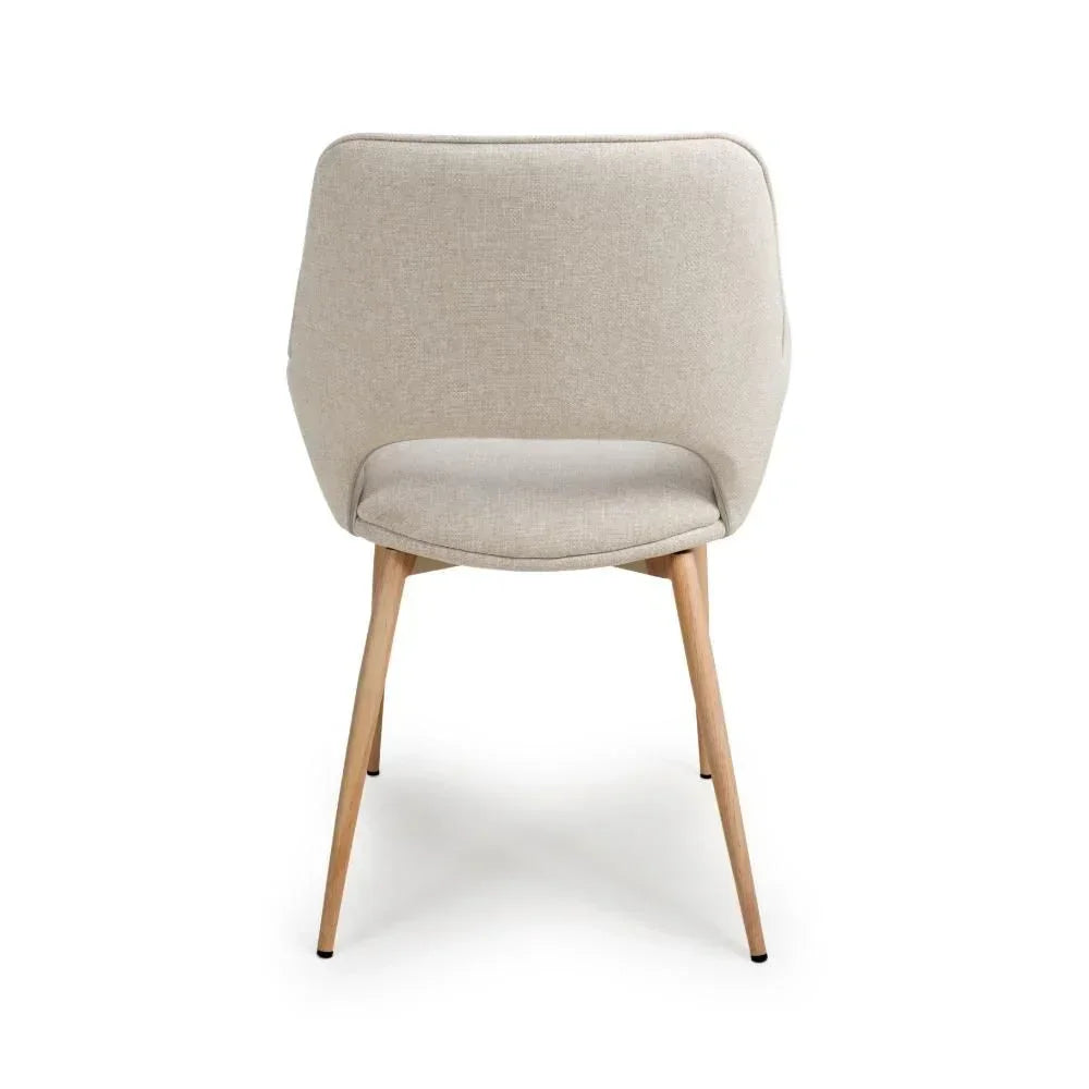 Beige fabric dining chair with curved back and light wood legs, rear view