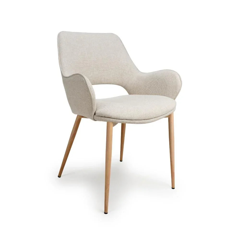 Beige fabric dining chair with curved arms and wooden legs on white background