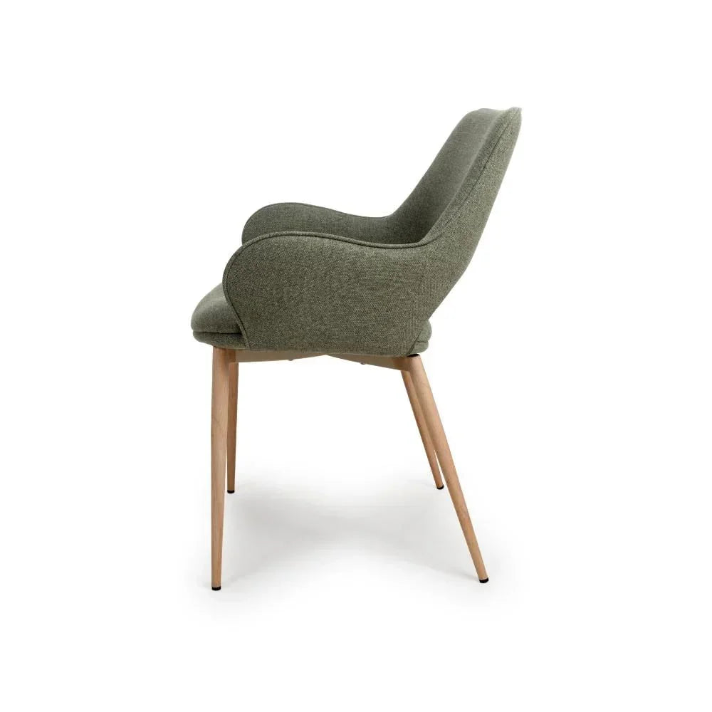 Side view of green fabric dining chair with curved backrest and wooden legs