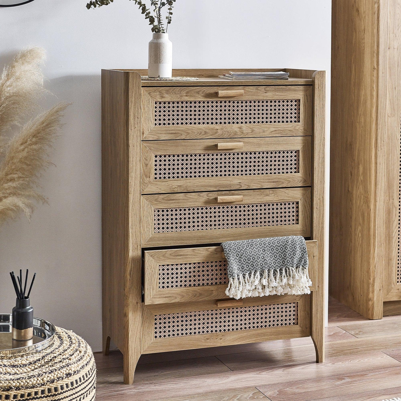 Sydney rattan effect 5 drawer chest with open drawer and decorative vase in modern room