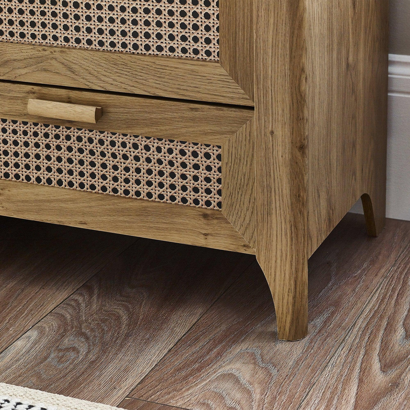 Rattan effect chest of drawers corner detail with natural wood finish and cane drawer front