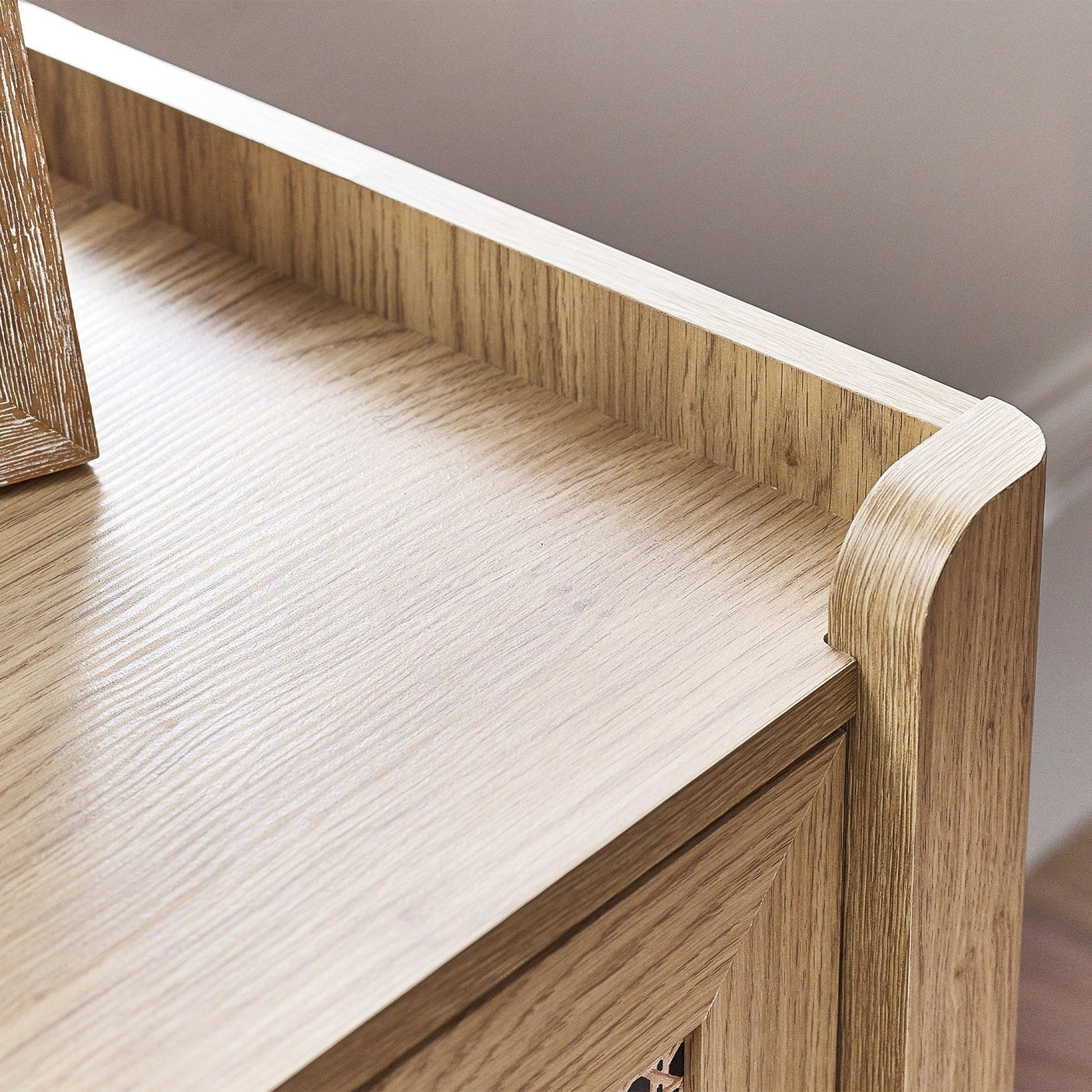 Close up of Sydney rattan effect 6 drawer chest corner with light wood grain finish
