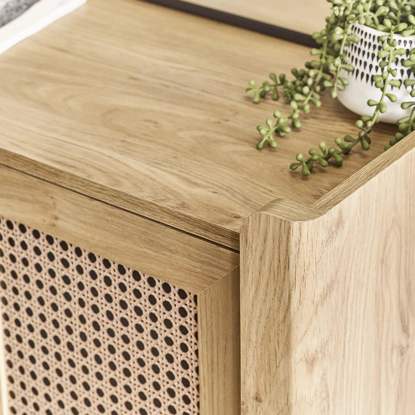 Rattan effect lamp table with light wood finish and decorative removable shelf detail