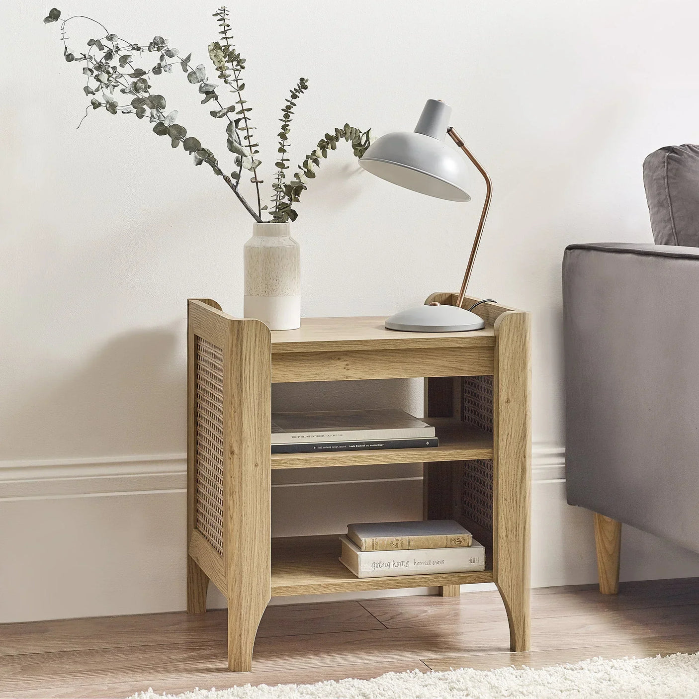 Sydney rattan effect lamp table with removable shelf beside sofa, styled with lamp and vase