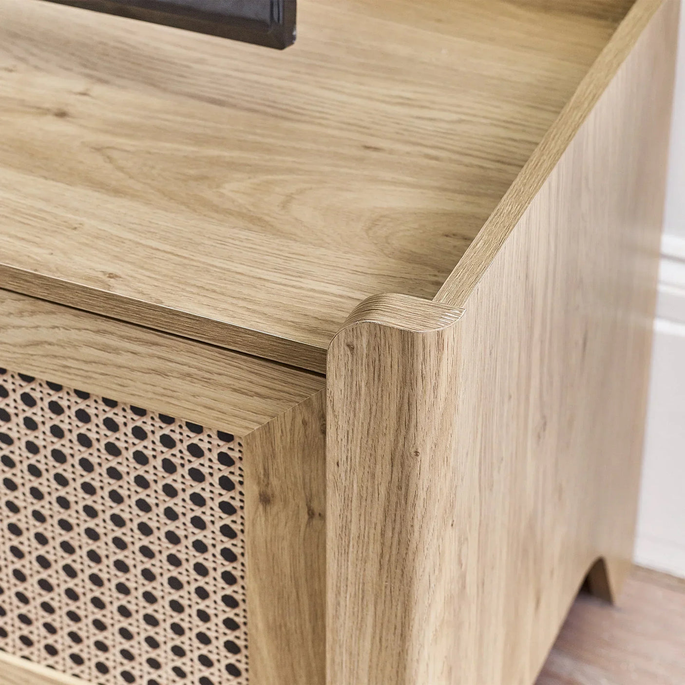 Close detail of rattan effect media unit with light wood finish and woven panel design