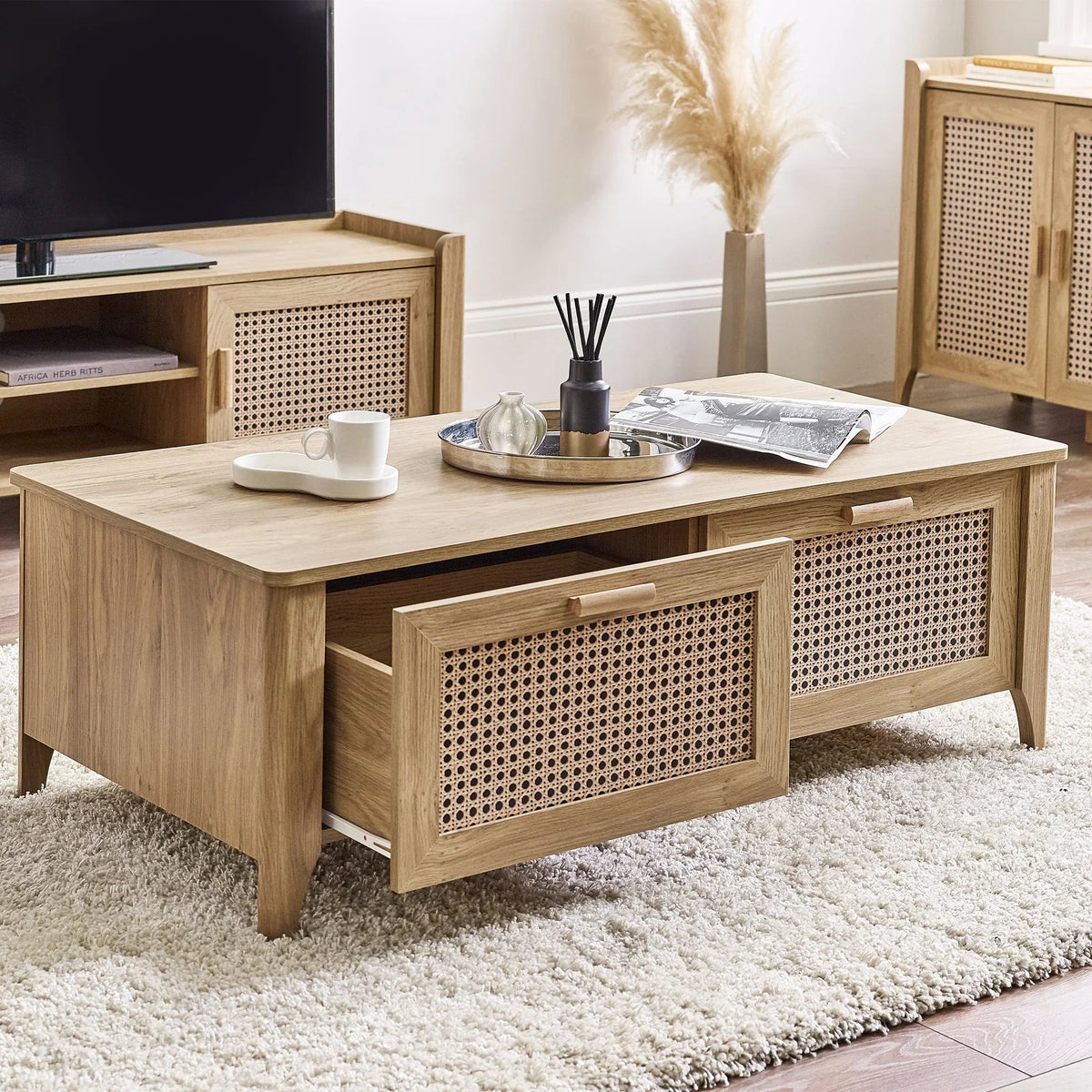 Rattan effect coffee table with two drawers on cream rug in living room setting