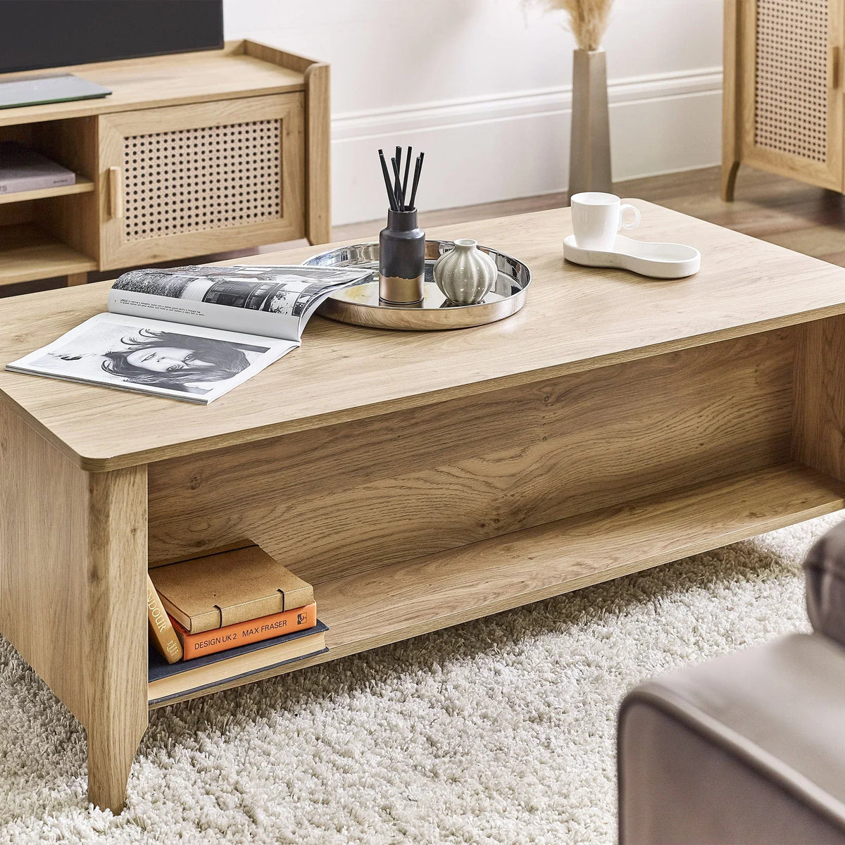 Light oak rattan effect coffee table with open shelf, styled with tray, books and decor